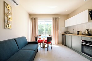 Uma sala de estar moderna com um sofá e uma mesa de jantar com cadeiras.