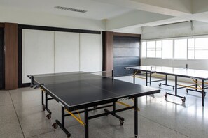 A room with a ping pong table, another table, and a large window. - 49sqm 1BR in Thonglor, pool and workspace (Watthana)