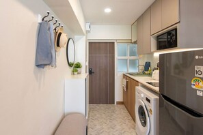 A compact kitchen with a washing machine, a refrigerator, and a microwave. - 49sqm 1BR in Thonglor, pool and workspace (Watthana)