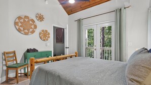 A bedroom with a bed, a wooden headboard, a green dresser, a chair, and a ceiling fan. - Gem of the Mountain -Cozy Cabin Retreat Near Helen (Sautee Nacoochee)