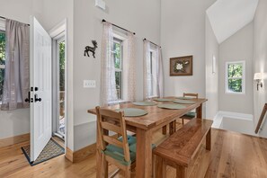 A dining area with a wooden table, chairs, and a bench. - Gem of the Mountain -Cozy Cabin Retreat Near Helen (Sautee Nacoochee)