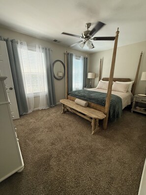 A bedroom with a four-poster bed, a ceiling fan, and a large window with curtains. - The Launching Pad: Beautifully updated, swim-tennis community, great location! (Acworth)