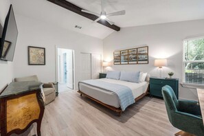 A bedroom with a bed, a desk, a chair, a ceiling fan, and a window with blinds. - Dog-Friendly Home: 2,000- Books & Board Games (Austin)