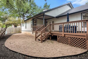 A house with a covered porch, a wooden staircase, and a fenced yard. - Dog-Friendly Home: 2,000- Books & Board Games (Austin)