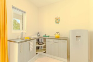 A compact kitchen with a sink, a kettle, and a refrigerator. - Hideout Dream Big Suite- From Eagle Beach (Noord)
