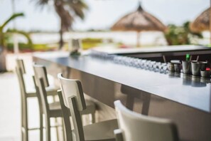 A bar area with chairs and a counter, likely part of a hotel or resort. - Gated Gold Coast 1BR, 75 m², 3 pools, near Malmok (Noord)