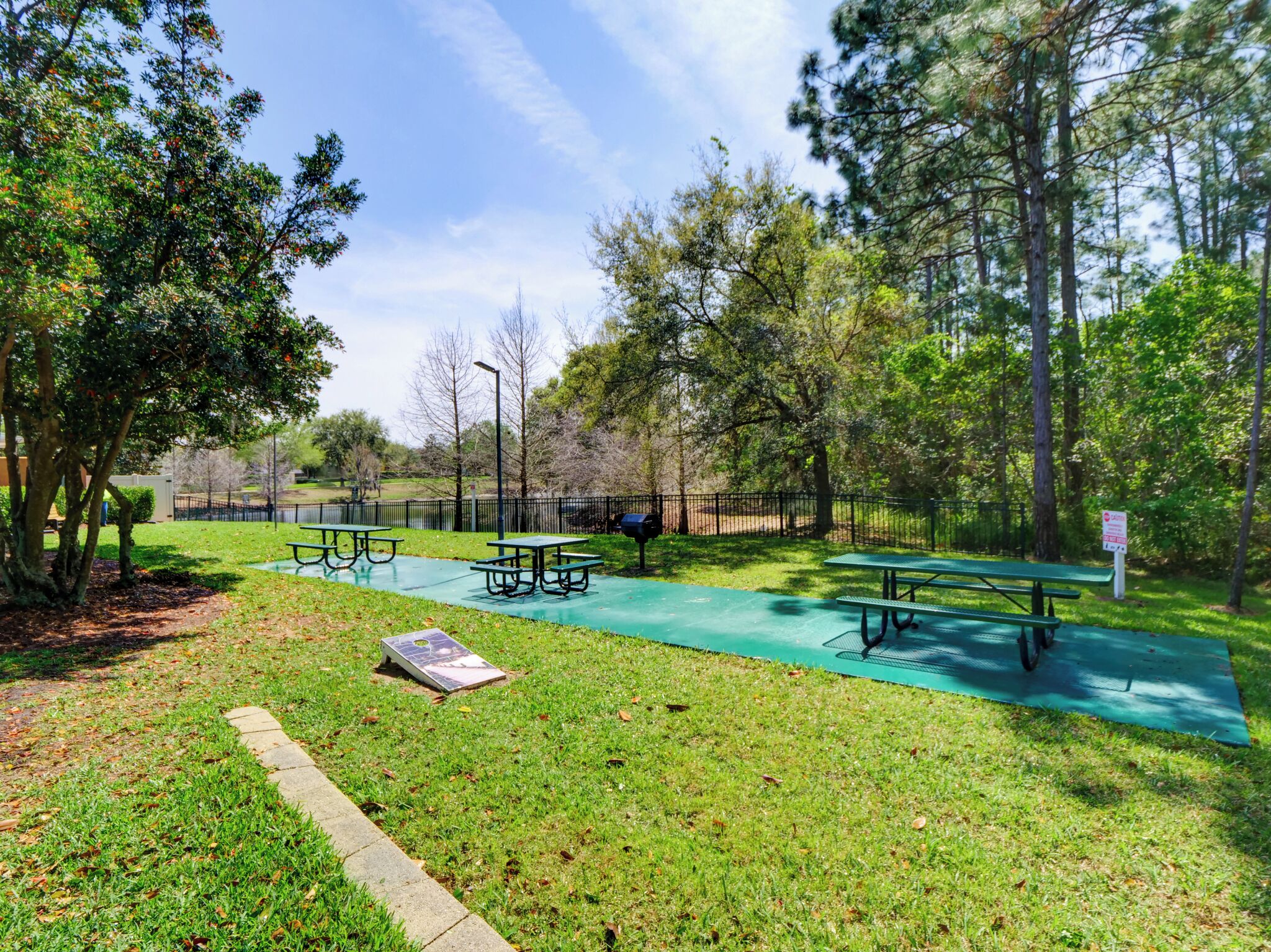 A park with picnic tables and a paved area.