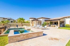 A pool area with lounge chairs, a pergola, and a patio with outdoor furniture. - Luxury Mediterranean Villa in Querencia (San José del Cabo)
