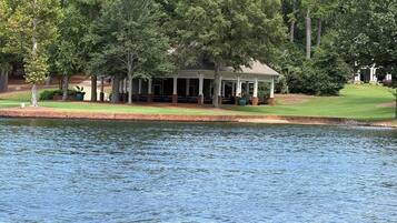 A lakeside pavilion with outdoor seating and a view of the water.