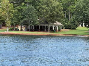 Un pavillon au bord du lac, doté d’un espace extérieur aménagé et offrant une vue sur l’eau.