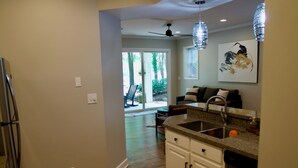 A kitchen with a built-in dishwasher, a sink, and a dining area with a table and chairs. - NEW LISTING Lake View In Reynolds on Oconee, 2bd/2bath Fully Remodeled Sleeps 6 (Greensboro)