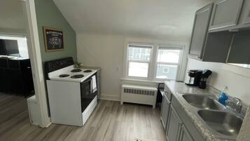 A compact kitchen with a stove, oven, and a window.