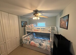 A bunk bed with a turtle-themed bedspread, a ceiling fan, and a window with blinds. - Mystic Island Lagoon Front Escape with Private Dock and Hot Tub ⚓️☀️ (Little Egg Harbor Township)