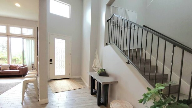 Ein geräumiger Wohnbereich mit Treppe, einer Bank und einer Topfpflanze.