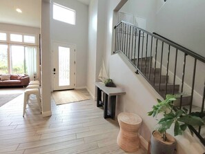 Un vaste espace de vie comprenant un escalier, un banc et une plante en pot.
