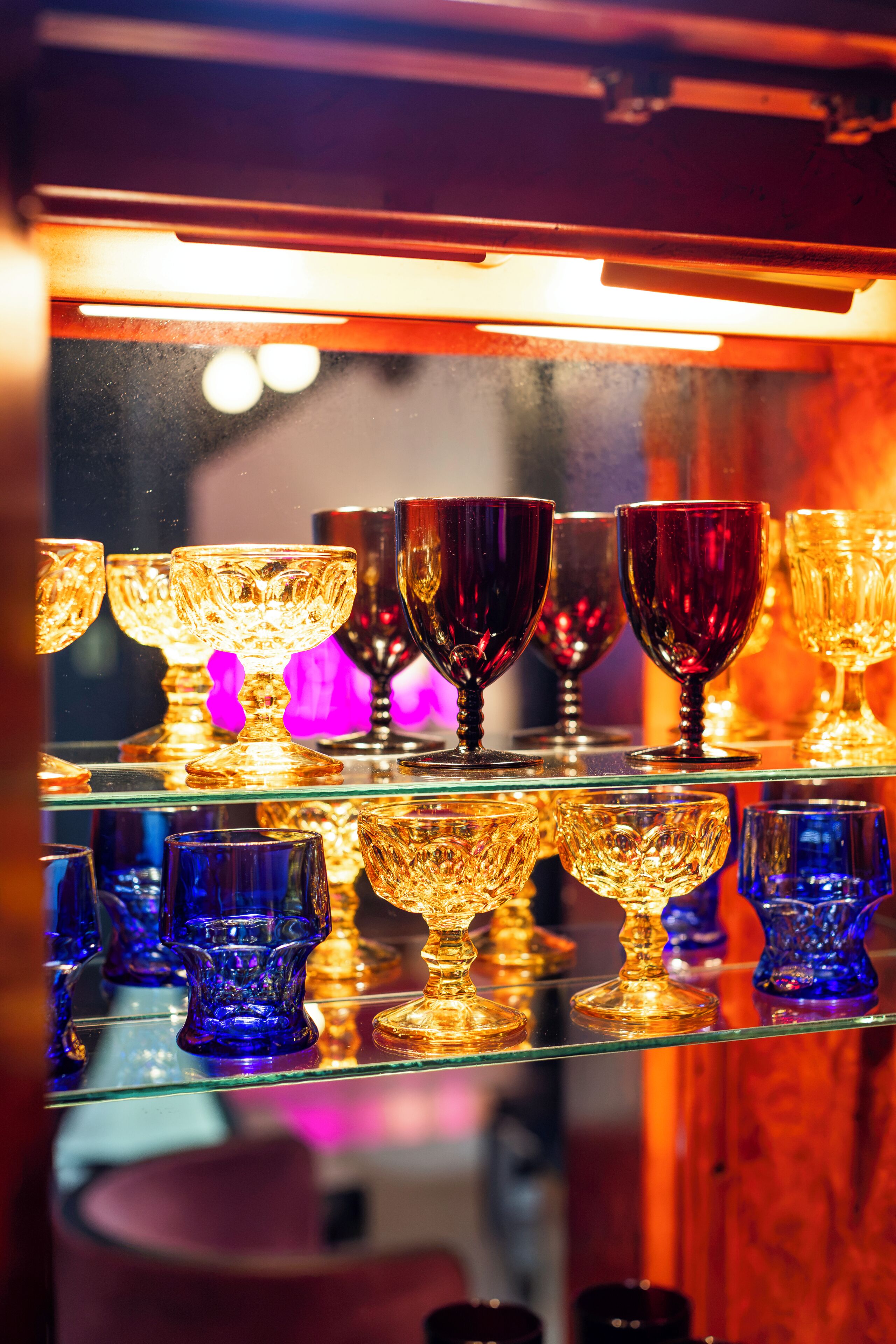 A display of various glassware items on shelves.