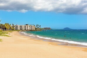 A beach with a hotel, clear skies, and ocean waves. - Tropical Maui Vista (Kihei)
