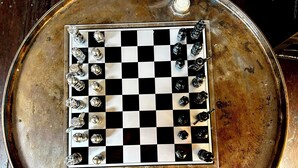 A chessboard with pieces on a metallic surface. - Hotelschiff KANAL77 - Schlafen im Hafen (Hamburg)