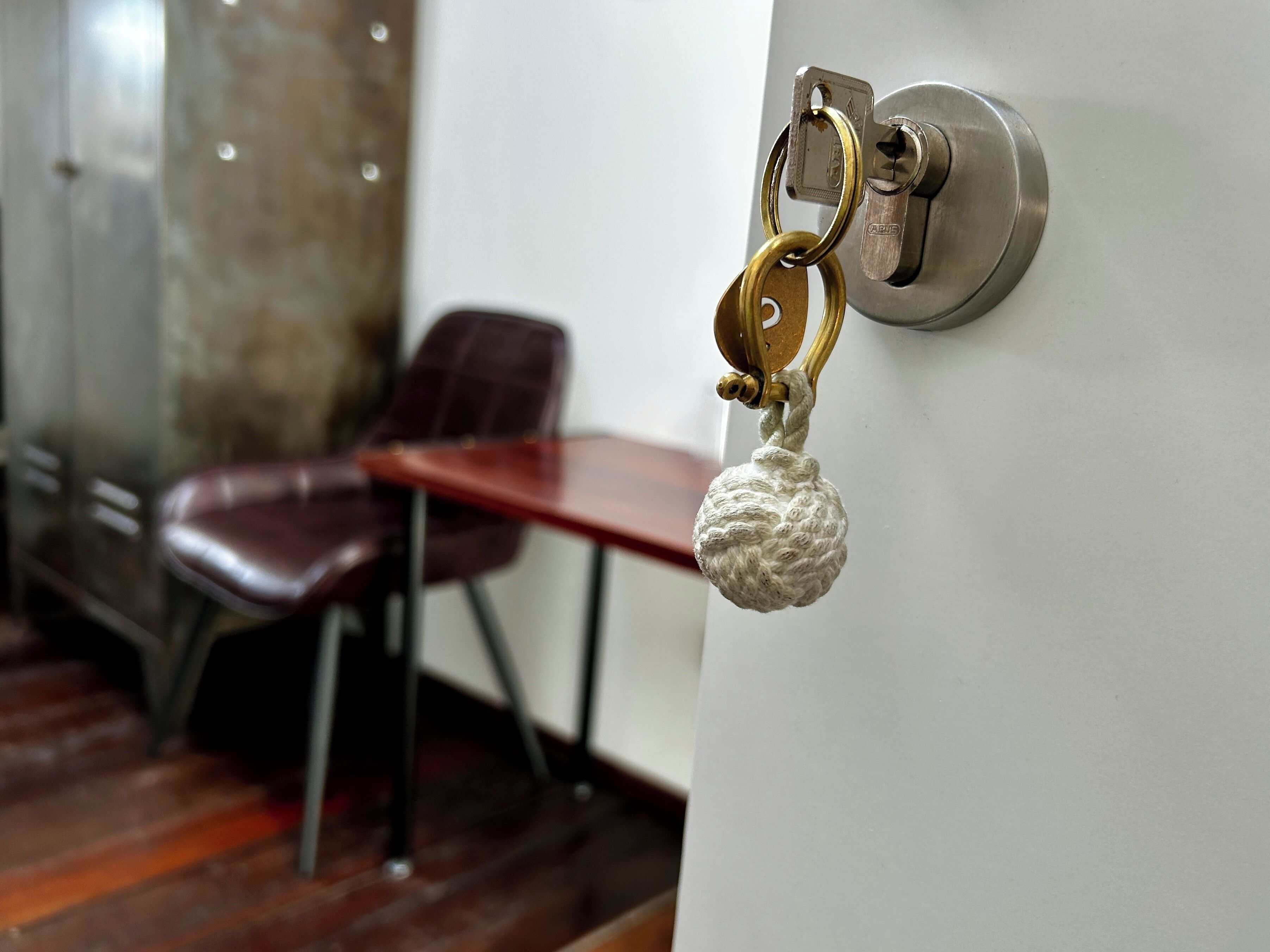 A door with a keyhole and a keychain with a key and a decorative item.