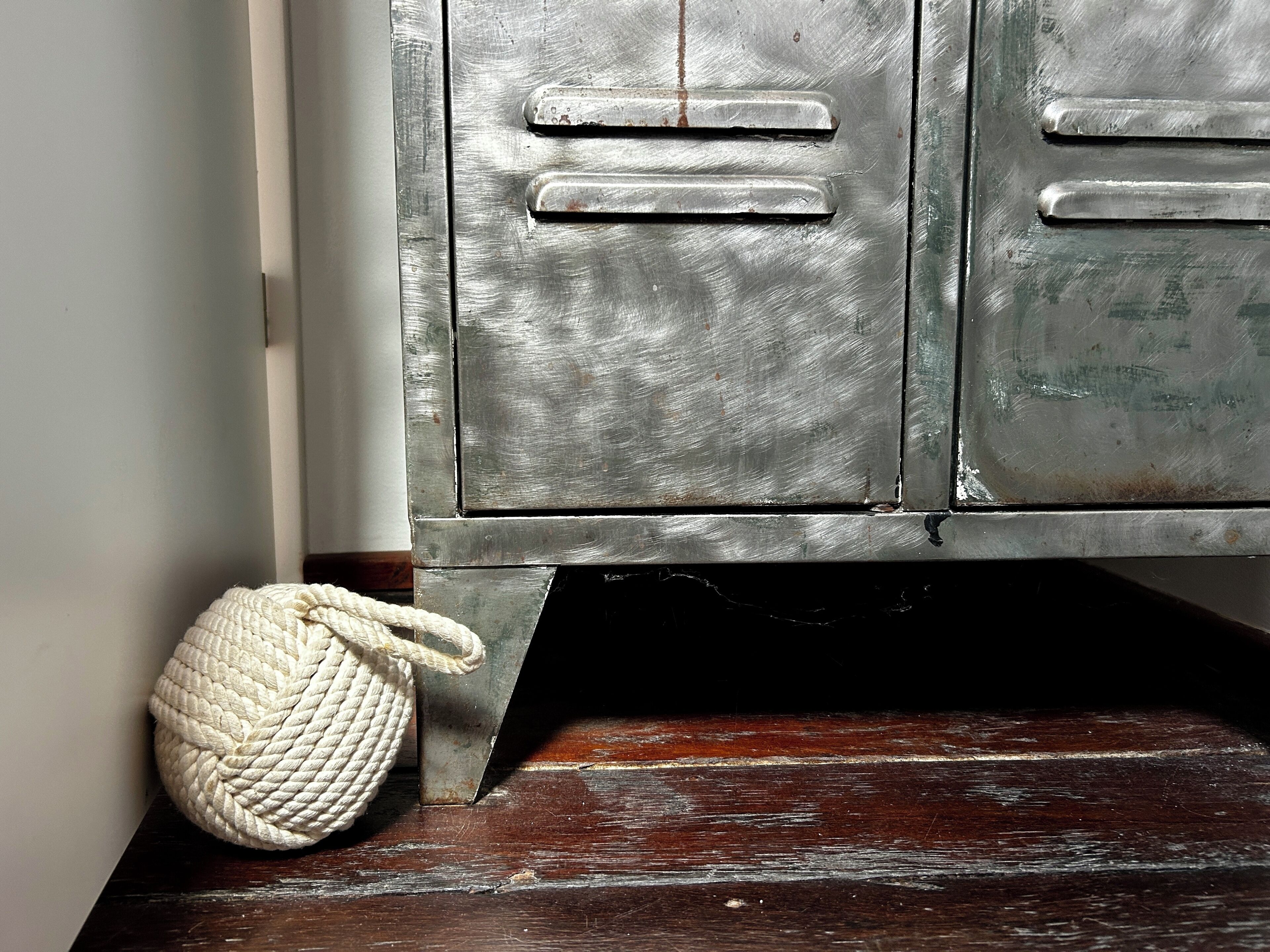A rustic wooden floor with a white rope ball.