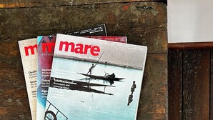 A stack of magazines on a wooden surface. - Hotelschiff KANAL77 - Schlafen im Hafen (Hamburg)