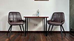 A room with two leather chairs, a wooden table, a bottle of water, and a map on the wall. - Hotelschiff KANAL77 - Schlafen im Hafen (Hamburg)
