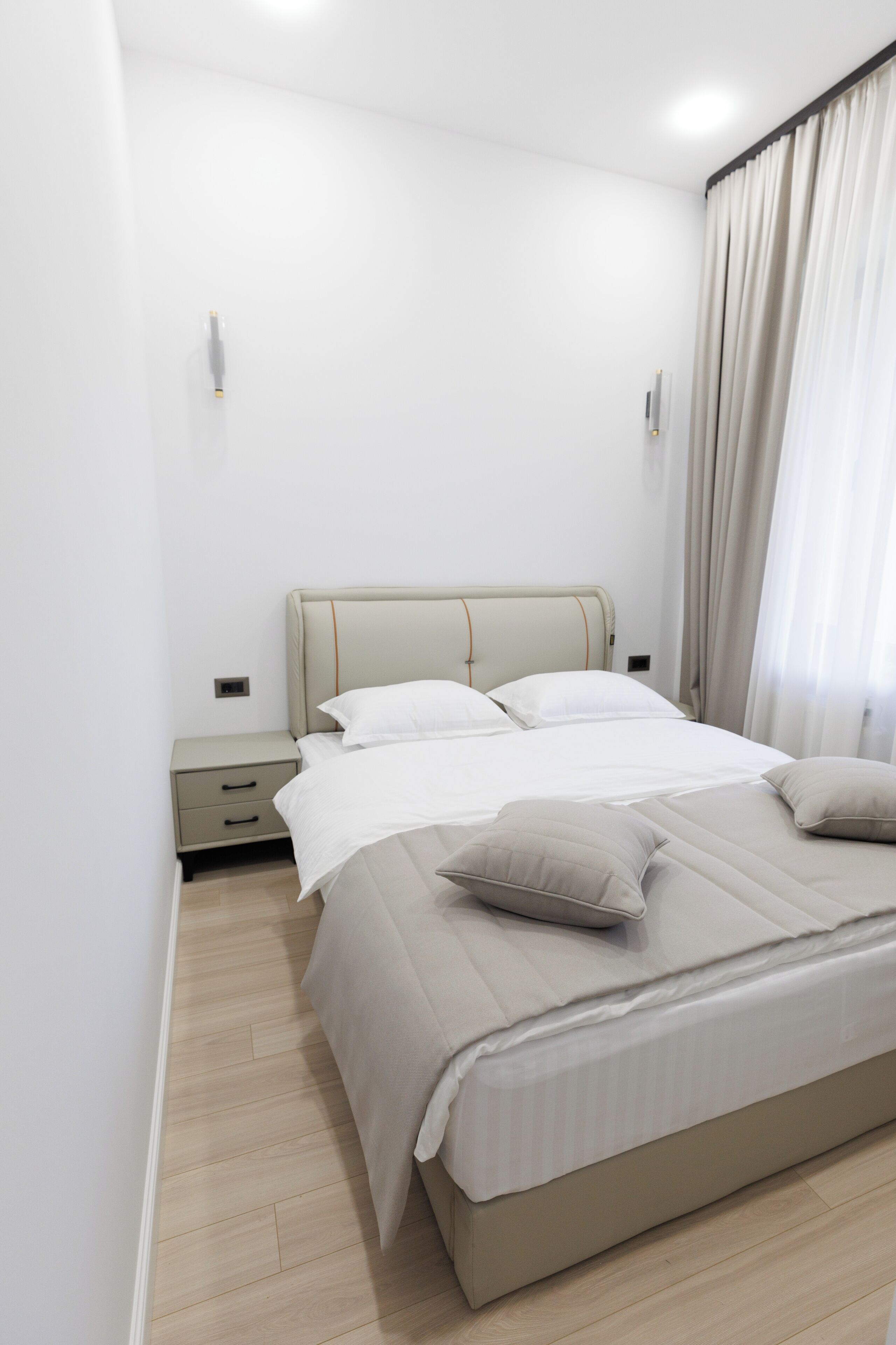 A bedroom with a bed, bedside tables, and a nightstand.