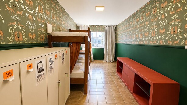 Un dormitorio con literas, escritorio y taquillas.