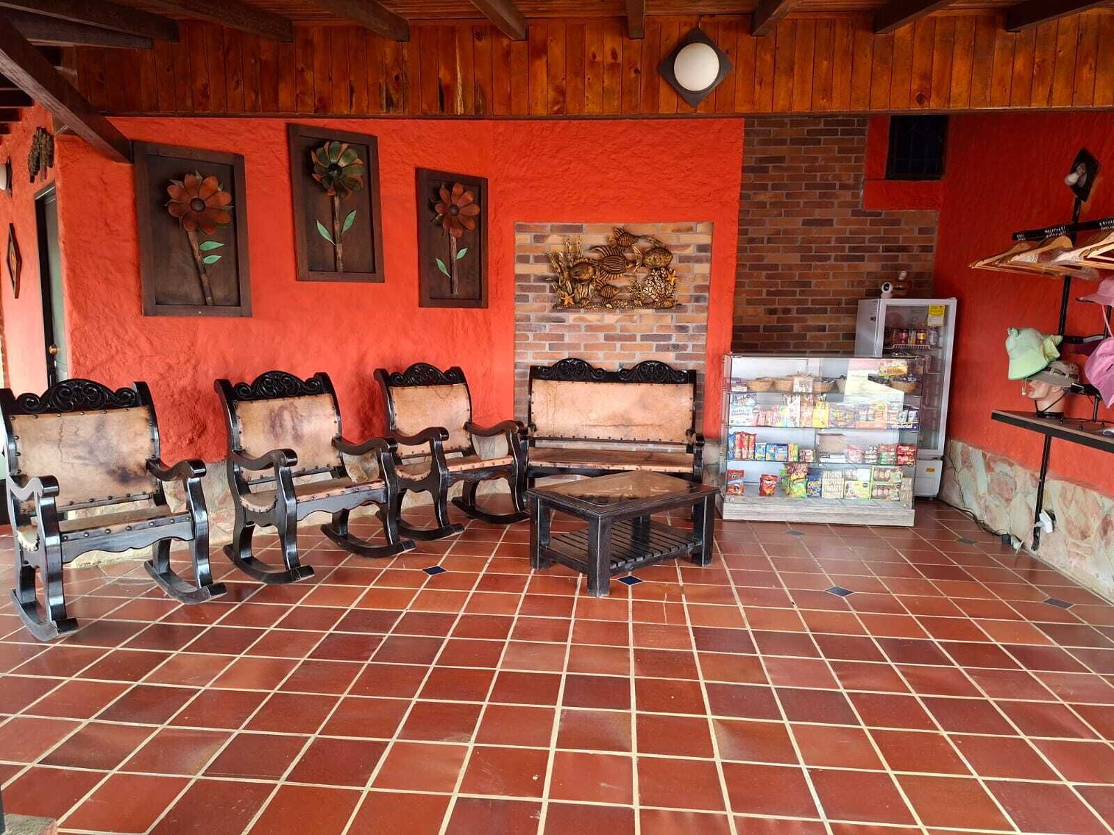 Um quarto com piso de azulejos, móveis de madeira, parede de tijolos e uma geladeira cheia de lanches.