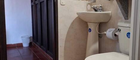 Een badkamer met toilet, wastafel en spiegel.