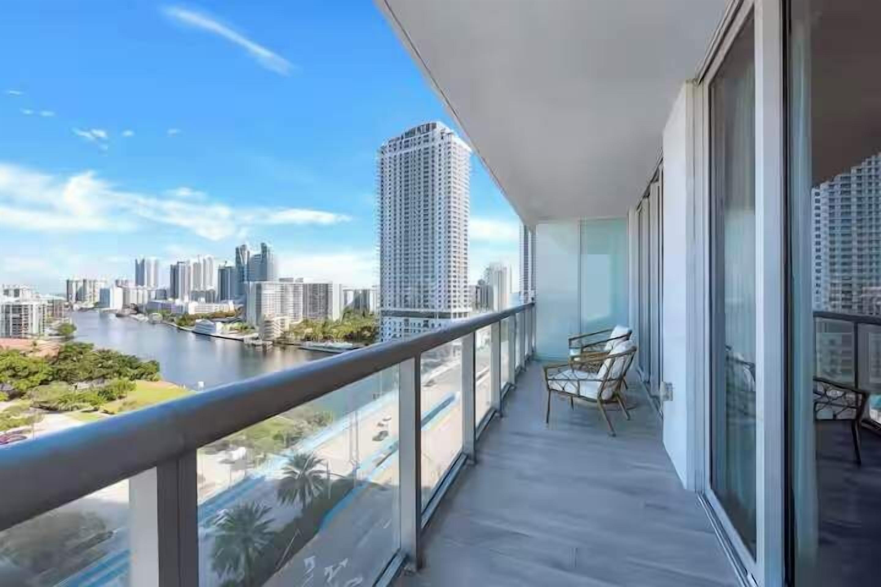 A balcony with a view of a cityscape and a river.
