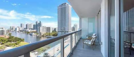 Un balcon donnant sur un paysage urbain et une rivière.