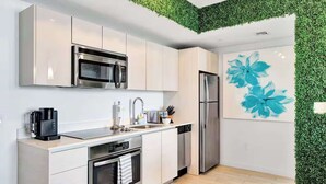 A modern kitchen with stainless steel appliances, a dishwasher, and a coffee maker. - 1BR North View, Balcony, Resort Pool & Beach (Hallandale Beach)