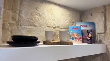 Een plank met zwarte borden, witte kopjes en een boek met de titel 'PIMPA gaat naar Lecce'.