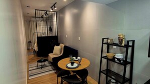 Un espacio habitable moderno con comedor, sofá, mesa de centro y estantería.