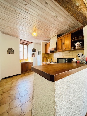 A kitchen with wooden cabinets, a tiled backsplash, and a hexagonal tile floor. - A 3-story, 110-square-meter house from the 17th century at the foot of the Cité de Carcassonne (Carcassonne)