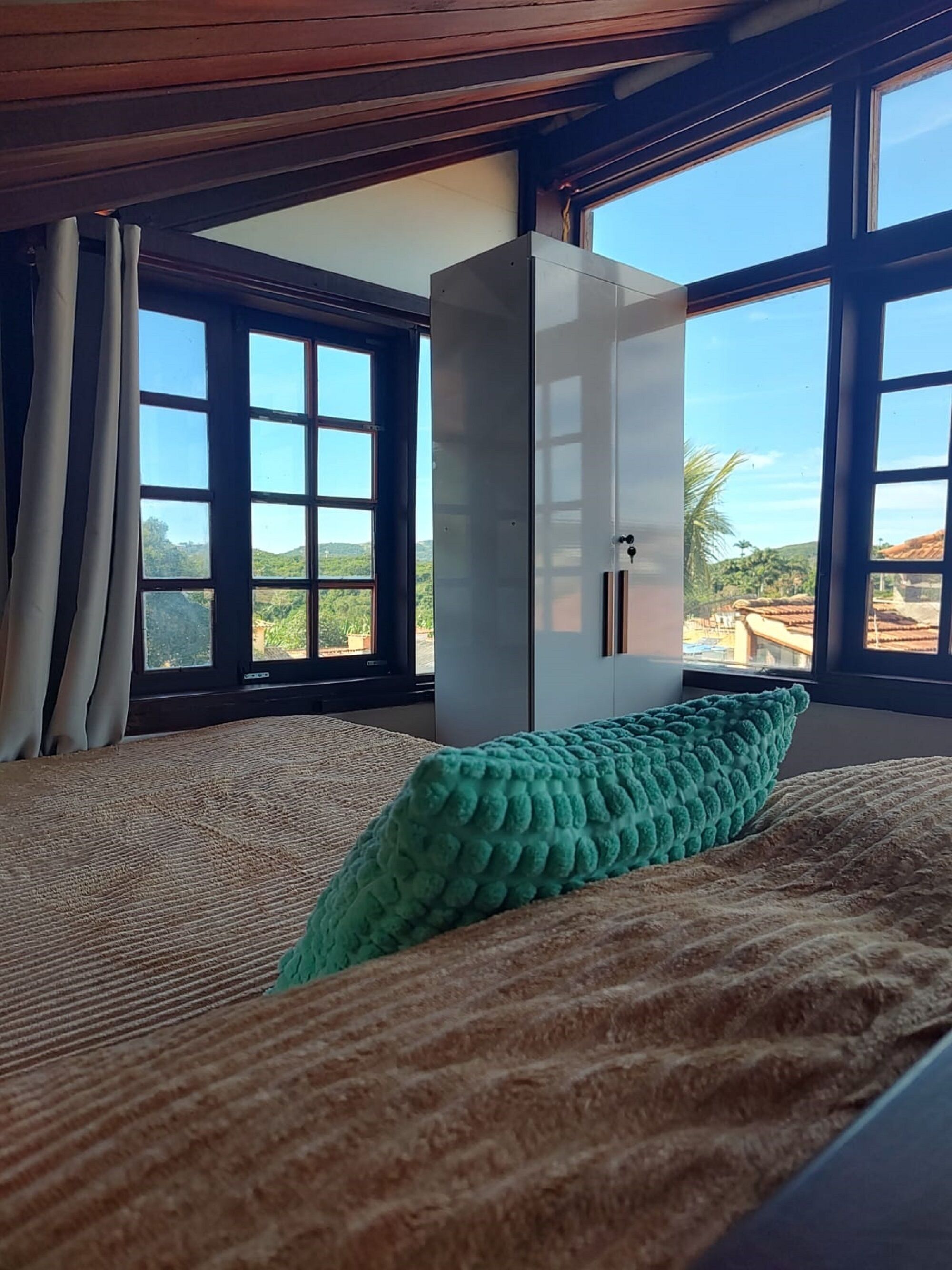 Una habitación con cama, un ventanal grande y un armario.
