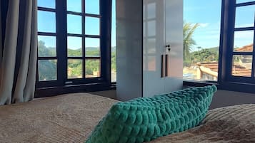 Una habitación con cama, un ventanal grande y un armario.