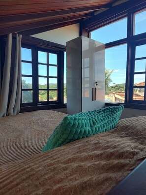 Una habitación con cama, un ventanal grande y un armario.