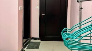 A hallway with a black door, a metal handrail, and a tiled floor. - Arecrata (Phnom Penh)