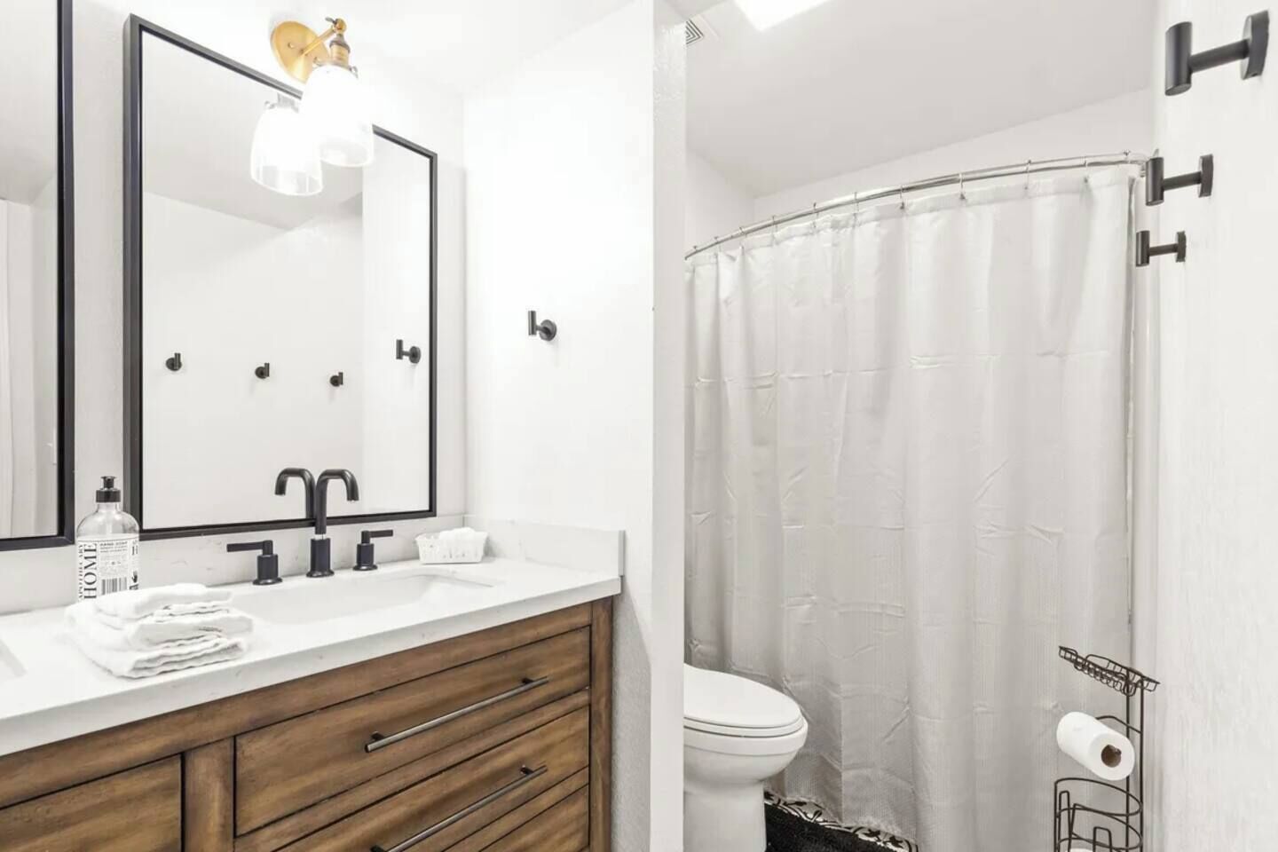 A bathroom with a white sink, mirror, and a shower curtain.