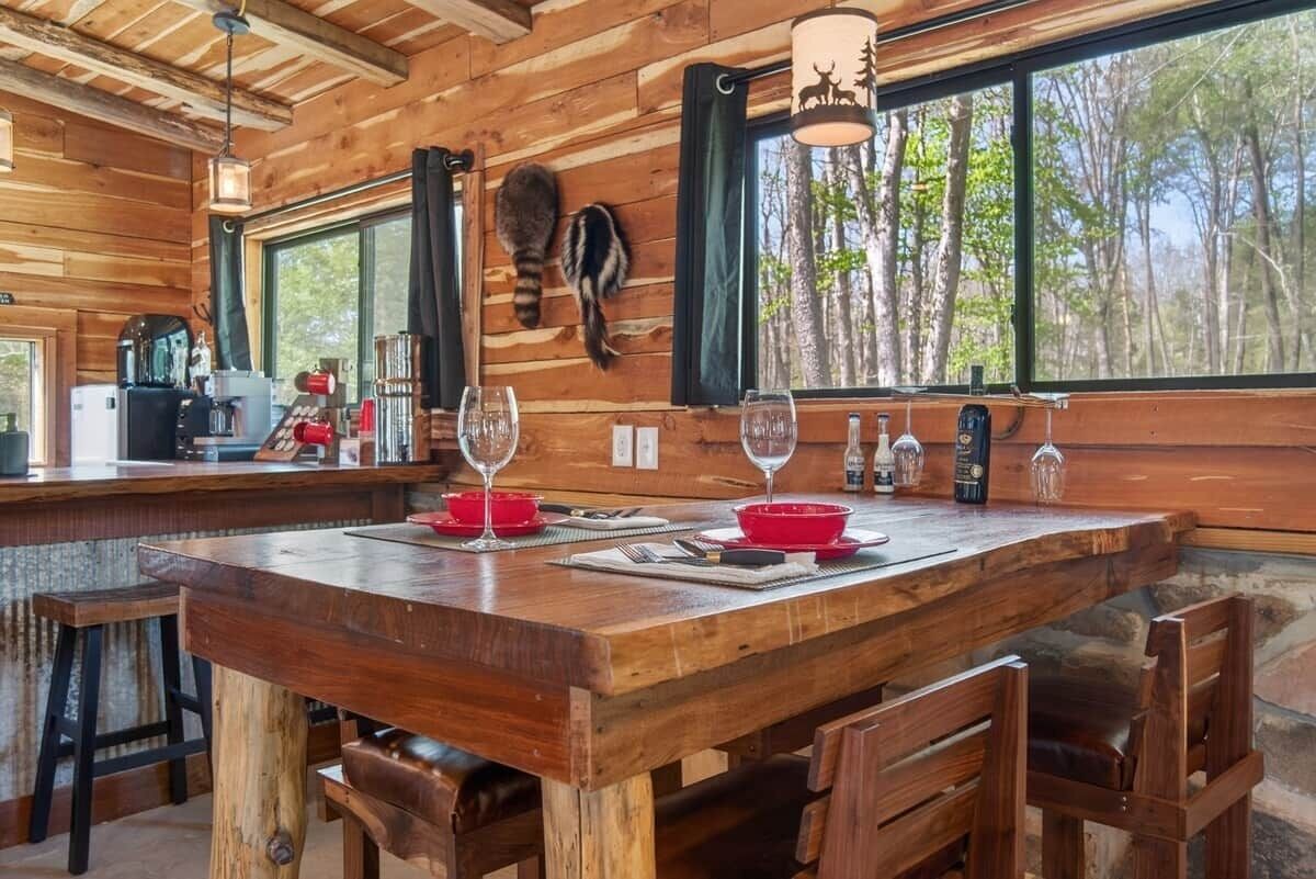 A wooden interior with a bar area, dining table, and chairs.