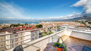 A balcony with a view of a coastal cityscape, including a marina and distant mountains. - Apartment with ocean views, a 10-minute walk from the waterfront (Roses)