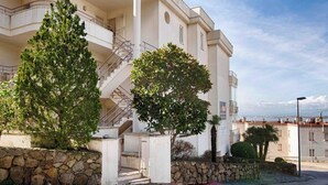 A two-story building with a stone facade, a balcony, and a staircase leading to the upper floor. - Apartment with ocean views, a 10-minute walk from the waterfront (Roses)