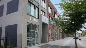 Ein modernes Gebäude mit einer Schaufensterschildausgabe 'DEFYEN eSurf efoil' und der Hausnummer 30 an der Fassade.