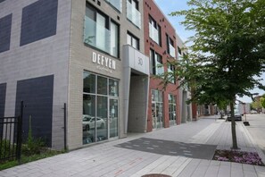 A modern building with a storefront labeled 'DEFYEN eSurf efoil' and a number '30' on the facade. - Le 102 Condo moderne au cœur de Magog (Magog)