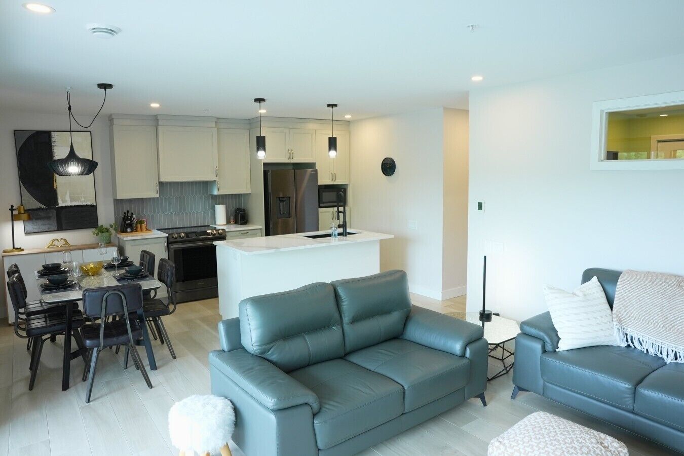 A modern apartment with a dining area, kitchen, and living room.