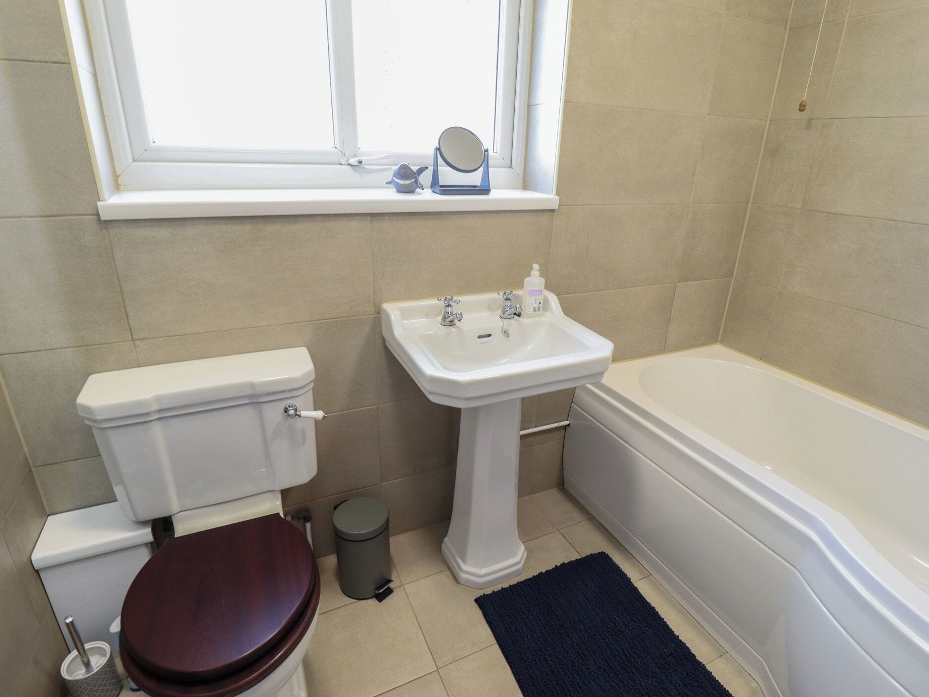 A bathroom with a toilet, sink, and bathtub.