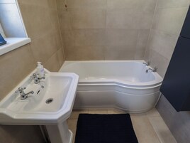 Un baño con lavabo, bañera y ventana.
