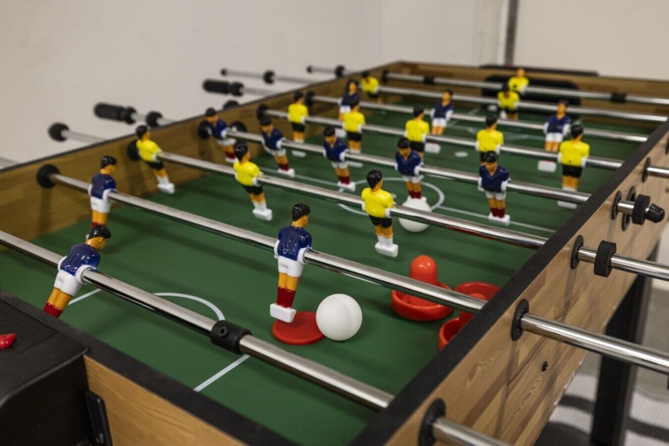 Ein Kicker mit Spielfiguren in blau und gelb.